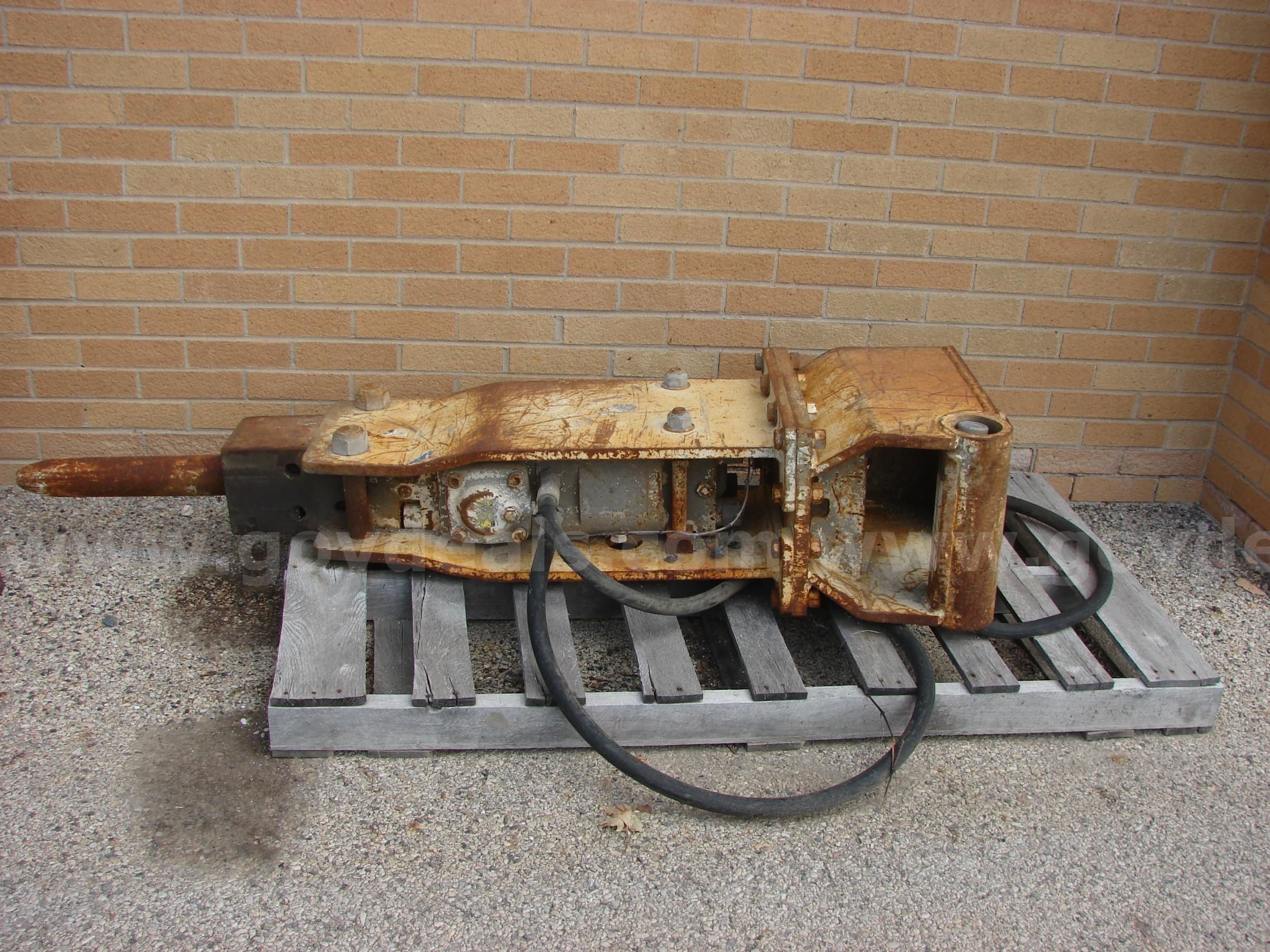 Backhoe hydraulic jack hammer attachment